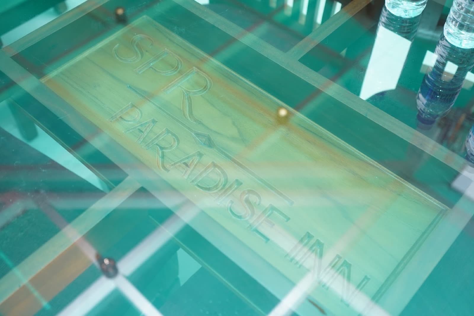 A glass sign cut with the words SPR Paradise Inn. The resort sites publish the name SPR Paradise Resort.